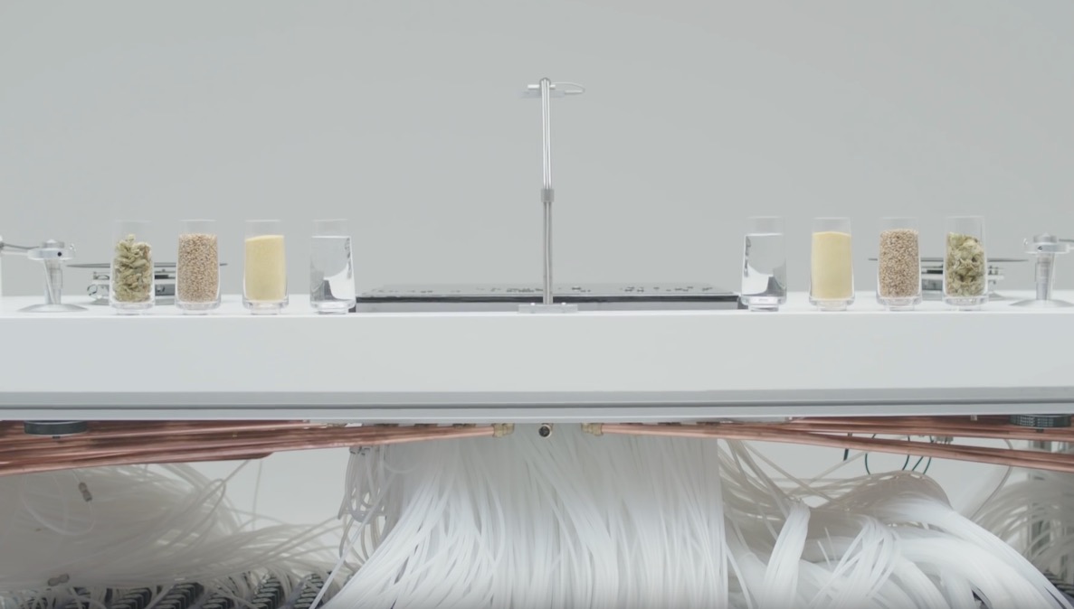 La Macchina è composta da un touch screen liquido e due turntables magnetici, su cui far girare dei vinili appositamente realizzati per l’esperimento. Lo schermo, alimentato ad acqua a ciclo continuo passante attraverso 8 km di tubi e 1800 valvole appositamente stampate, permette al Dj di controllare i due turntables e di muovere il lettore laser a sua discrezione. Il movimento del DJ sul touch screen è stato tracciato usando Leap Motion mentre alcuni dei loop e degli effetti ad essi applicati sono stati realizzati interpretando le forme generate con la tecnologia dei Cymatics.